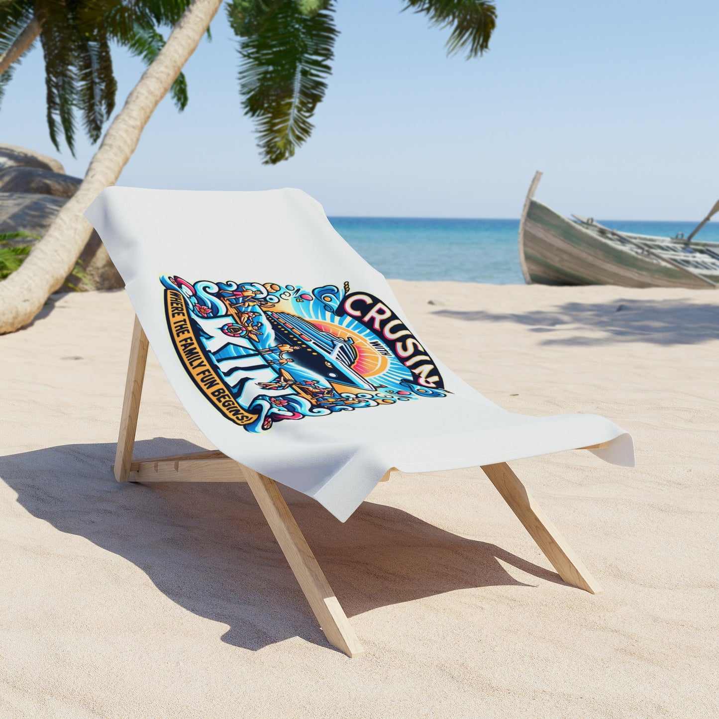 A white beach towel featuring a colorful "Cruising with Kin – Where the Family Fun Begins!" cruise ship graphic, draped over a wooden lounge chair on a tropical beach with palm trees, clear blue sky, and a boat in the background.