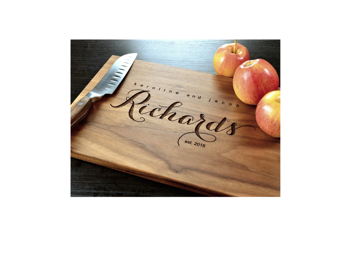 Wooden cutting board with engraved name 'Richard' and knife on a dark surface with apples.